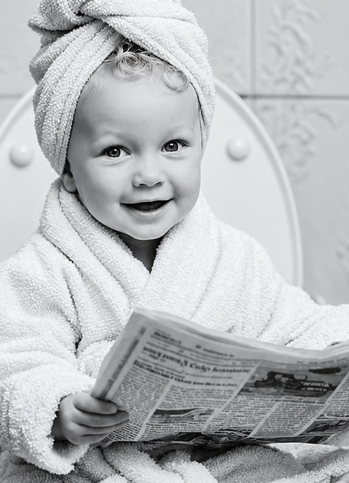 Detalhe da arte em preto e branco com bebê de roupão e toalha na cabeça lendo jornal.